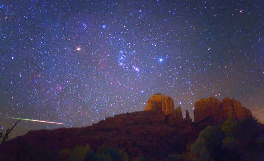 Glowing night sky of stars above Sedona's Cathedral Rock