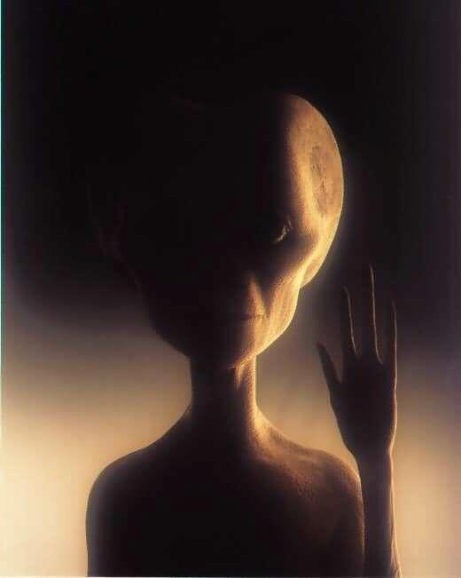 Grey Alien with big eyes and hand up